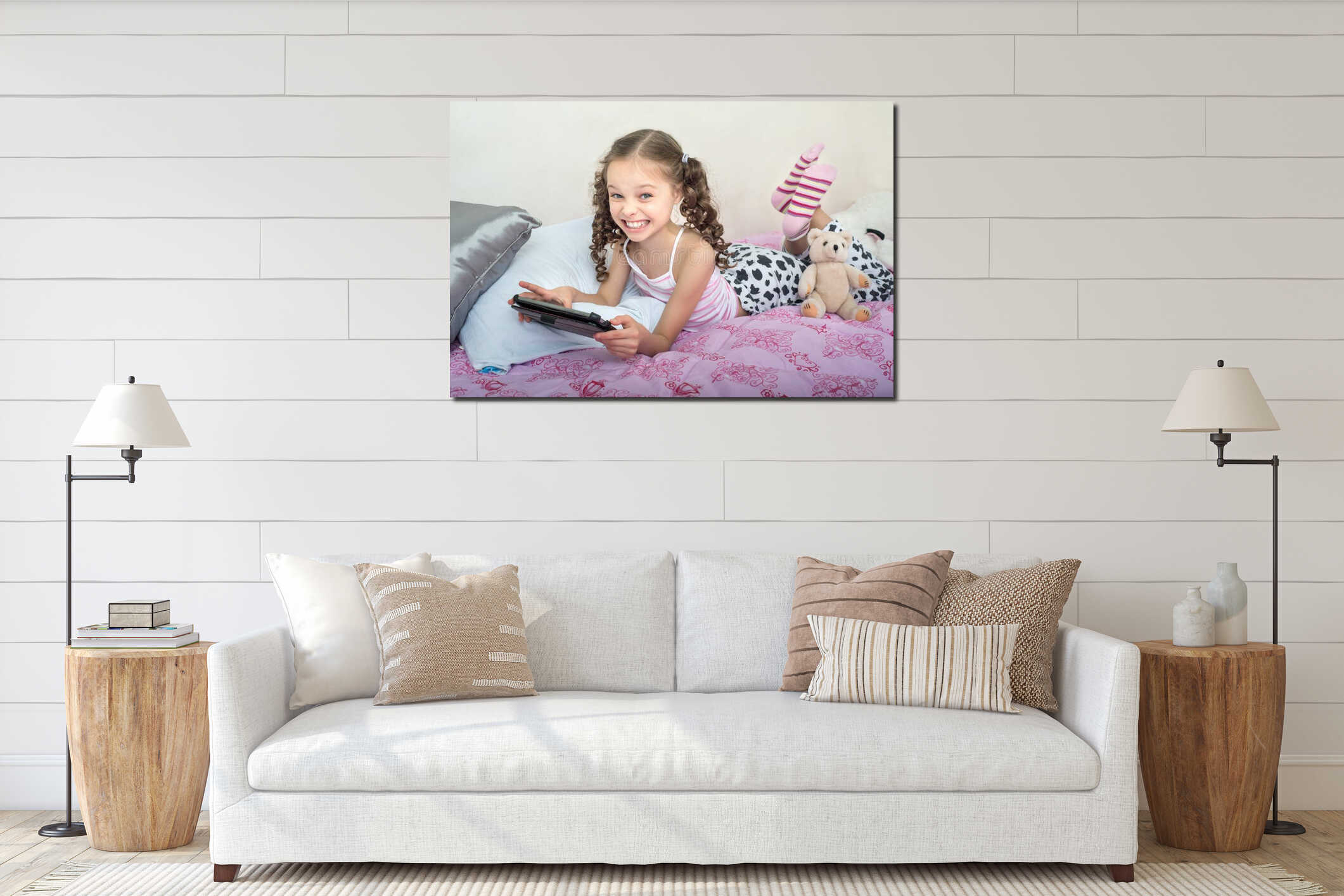 Happy little girl lying on bed with tablet computer interior mockup