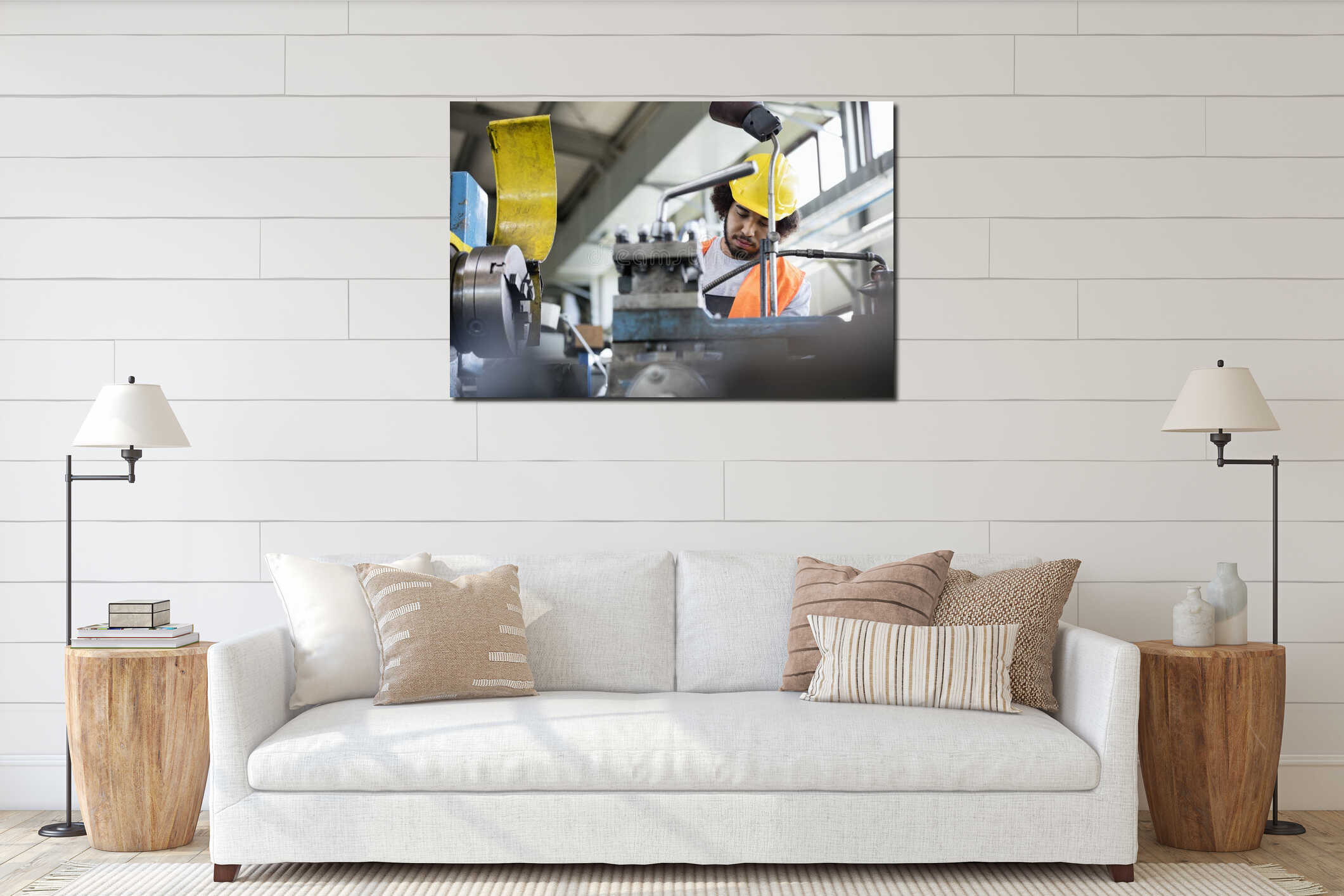 Low angle view of young manual worker working on machinery in metal industry interior mockup