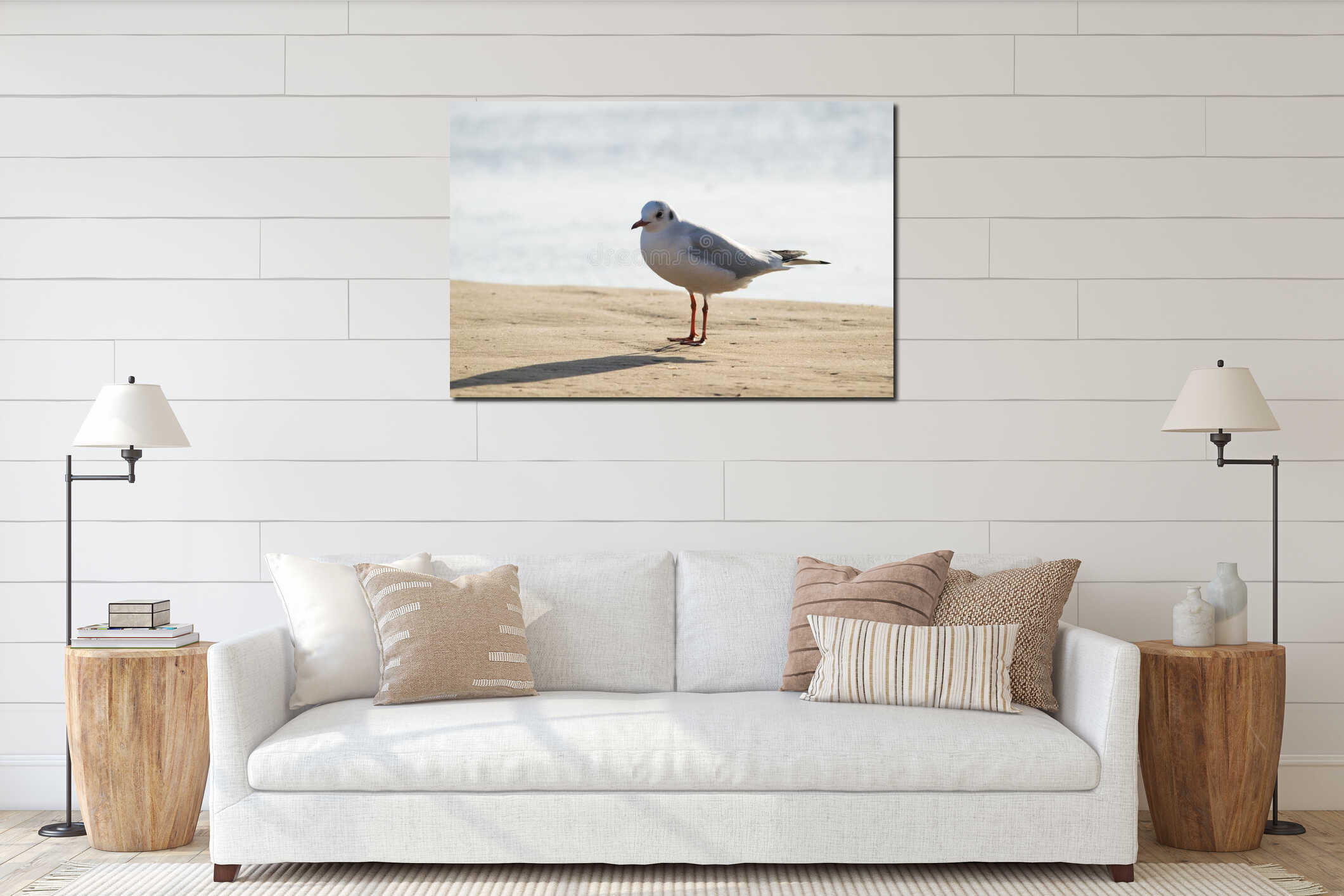Seagull standing on sand beach in front of the sea interior mockup