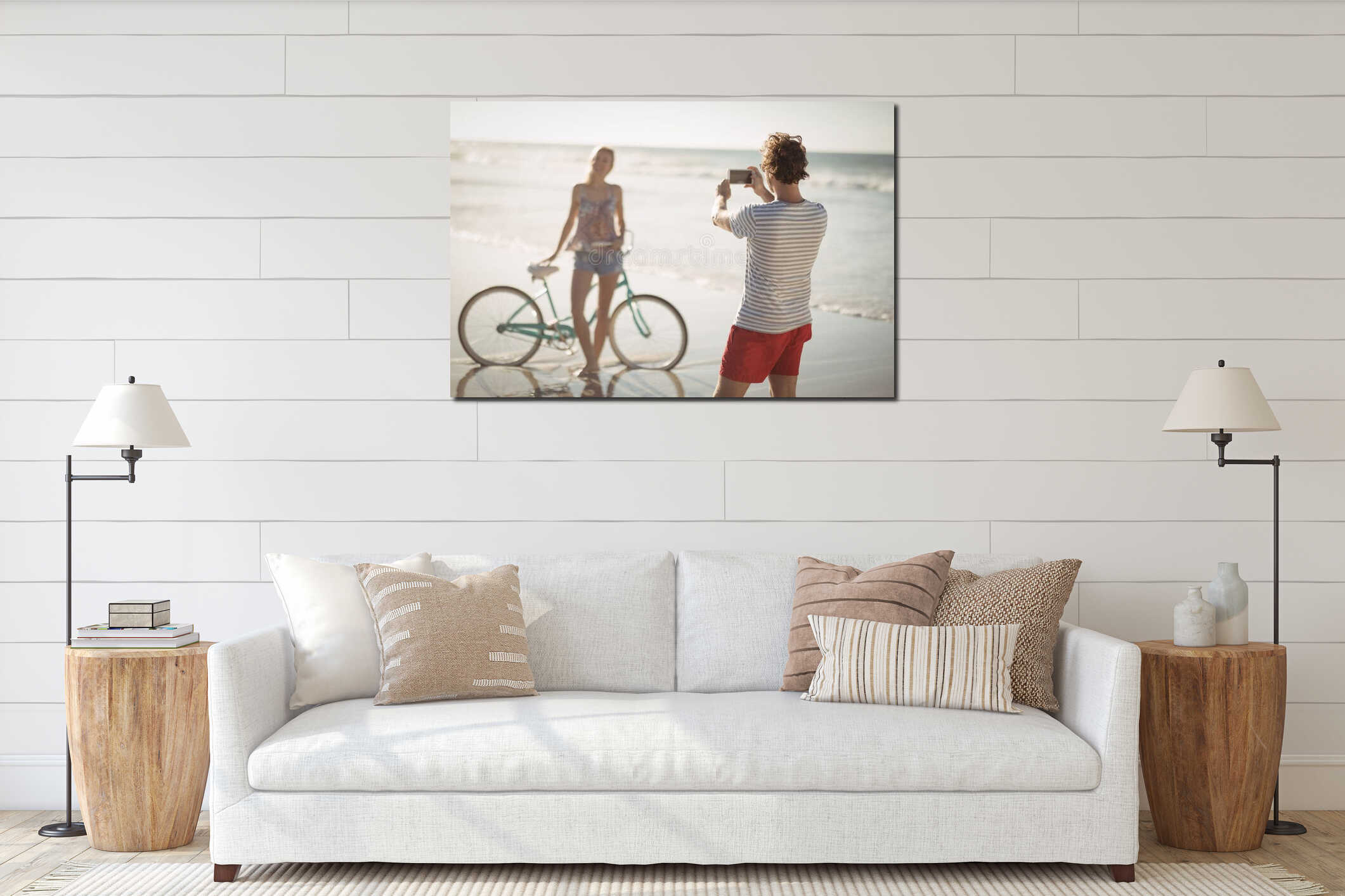 Man photographing woman standing by bicycle at beach interior mockup