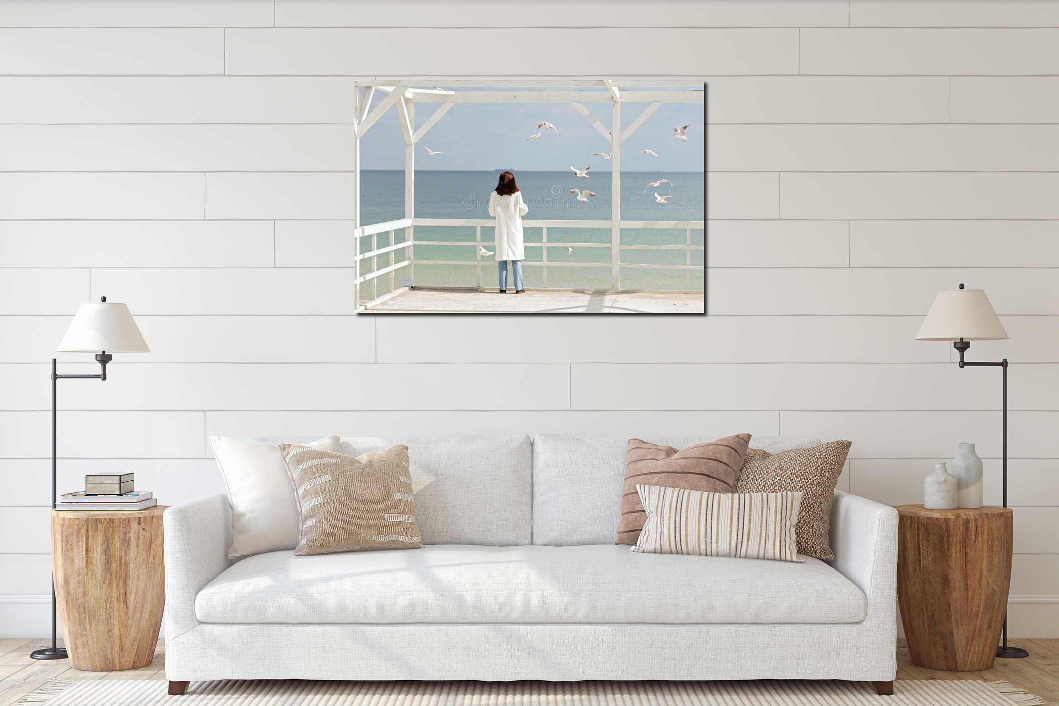 Young woman brunette in a white coat feeds the gulls on the be interior mockup